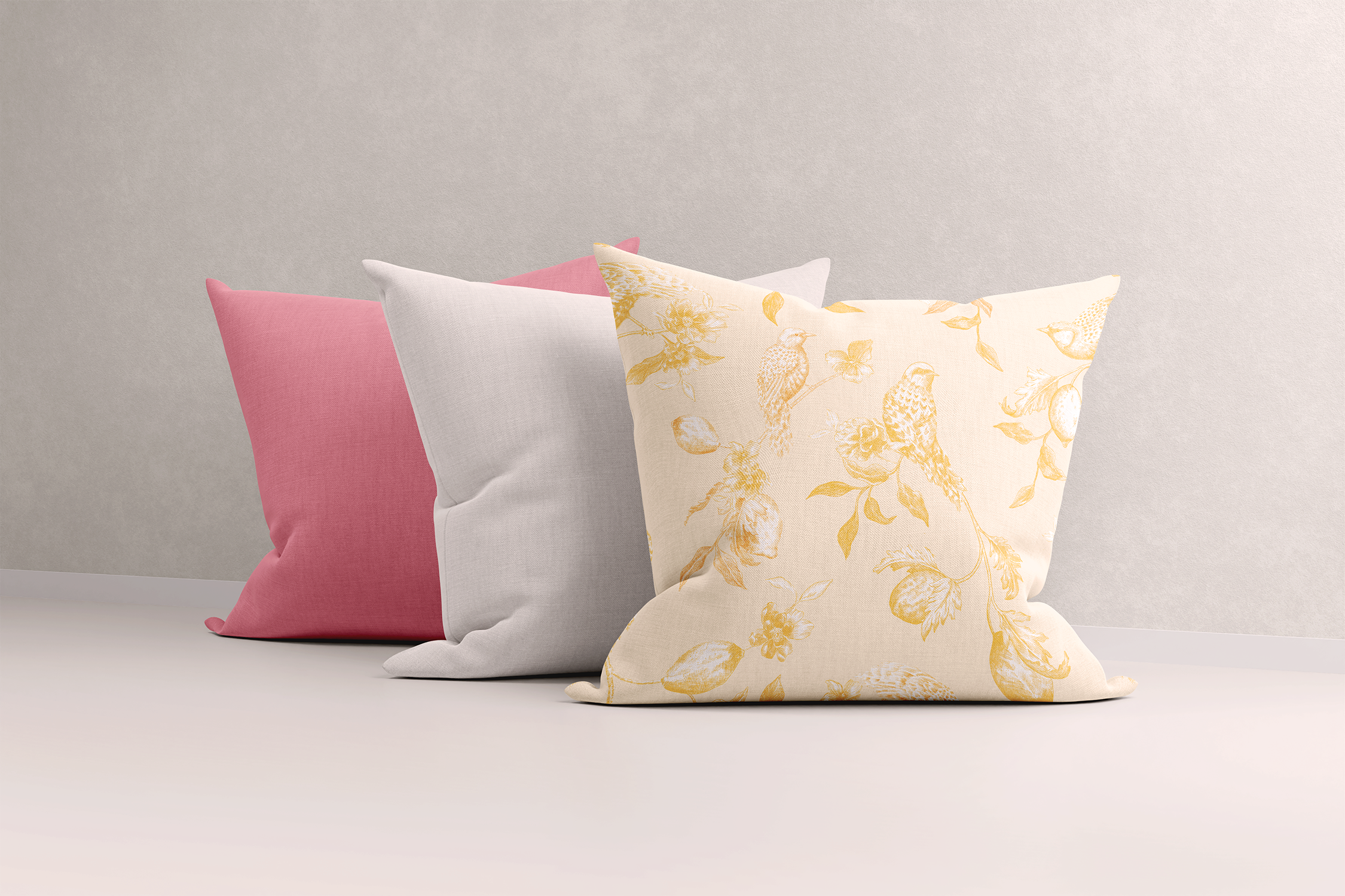 Trio of cushions against a plain backdrop featuring a lemon and bird print, pink, and plain white designs. The sugary pastel palette aligns with the trending pastel aesthetic, creating a soft and playful look with joyful, hand-painted patterns perfect for a pastel-themed decor.