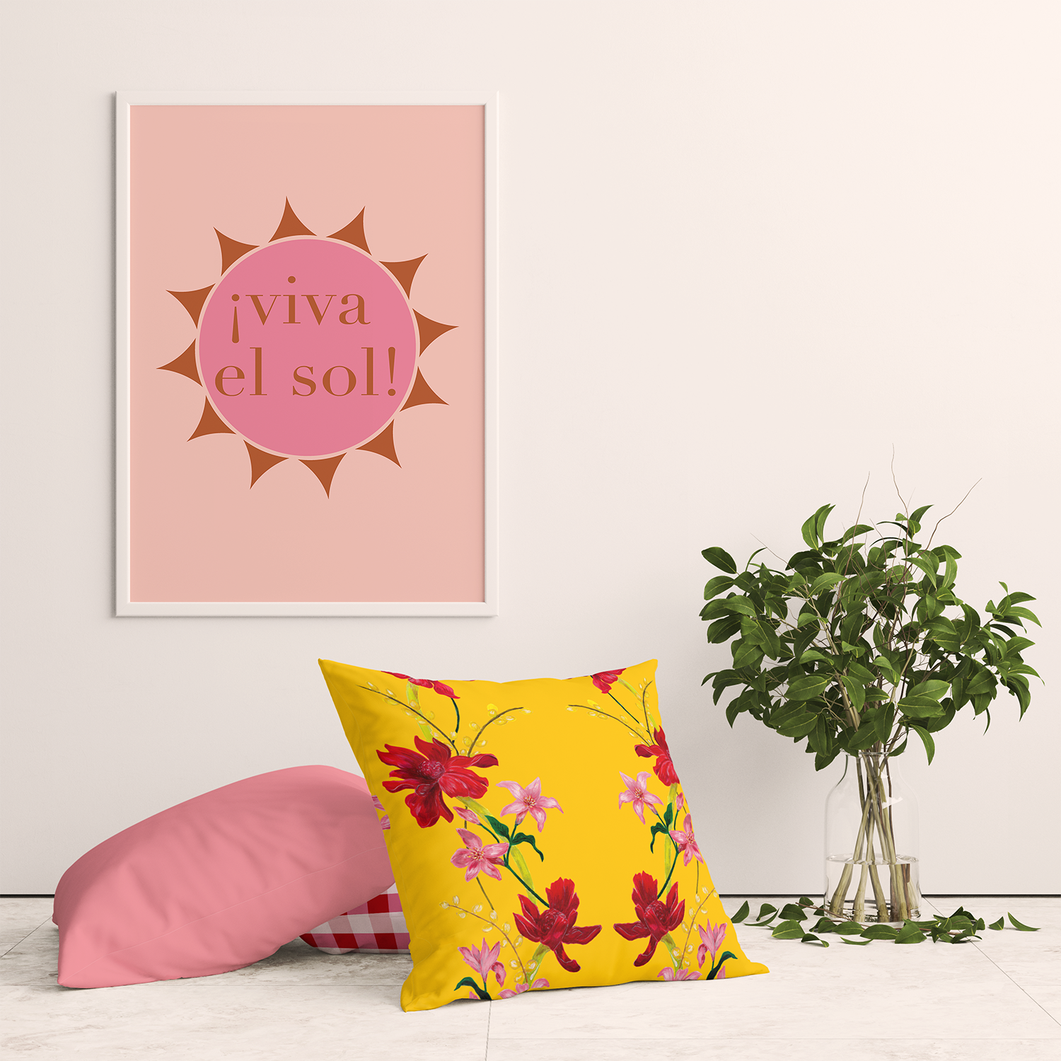 Interior scene with a vibrant sunny poster and a plant, complemented by unique cushion covers in tropical floral, red gingham, and pink patterns. Adds joyful decor and craft to a peach and pink interior, featuring hand-painted designs by an independent artist. Perfect for decorating with print and using color in space