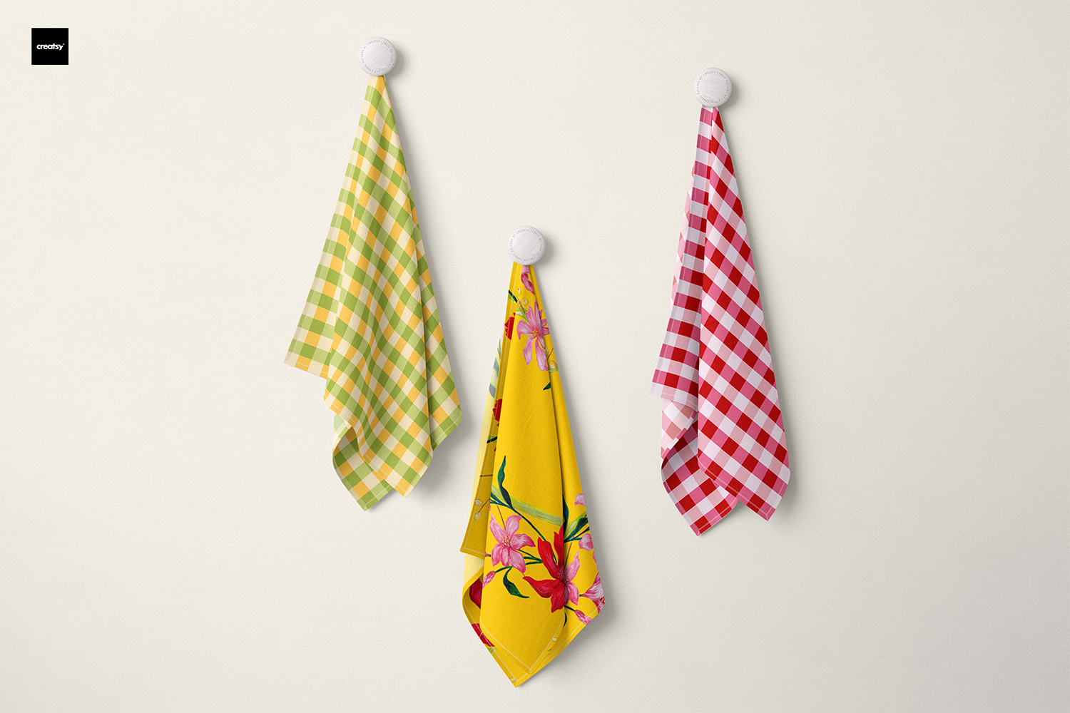 Three tea towels hanging on hooks: one with a golden tropical floral design, paired with green and red gingham tea towels. Bold, colourful, and joyful combinations that add a lively touch to your kitchen.